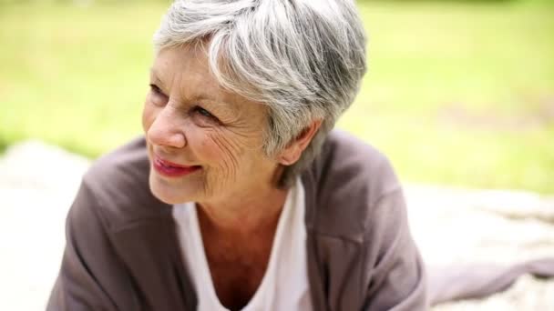 Happy senior kvinna avkopplande i den park tänkandet — Stockvideo