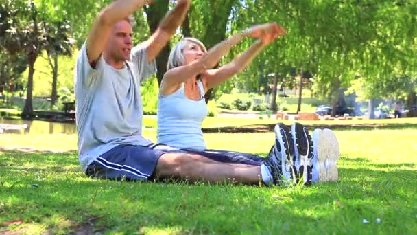 Par stretching tillsammans i parken — Stockvideo