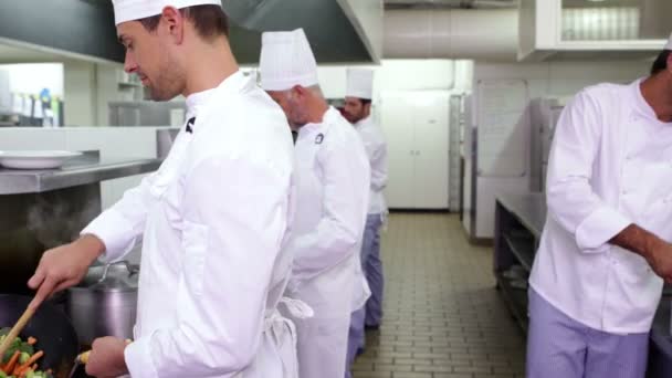 Smiling chef frying vegetables in a wok — Stock Video