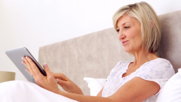 Glückliche Frau mit Tablette im Bett — Stockvideo