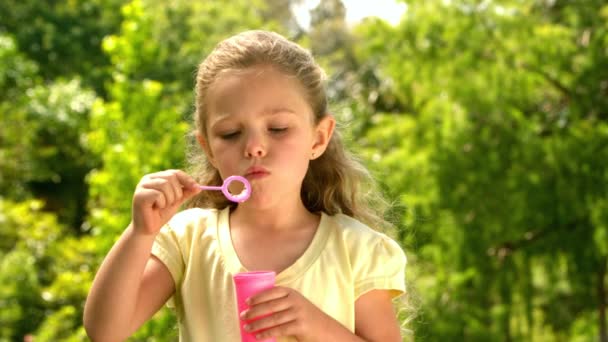 Μικρό κορίτσι, φυσώντας φυσαλίδες στο πάρκο — Αρχείο Βίντεο