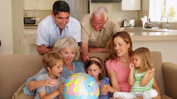 Famille élargie regardant globe ensemble sur le canapé — Video