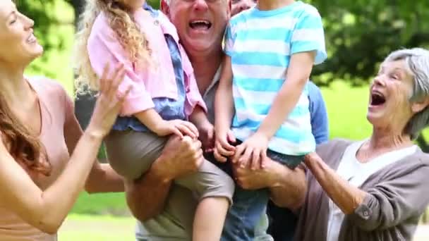 Uitgebreide familie staande in het park samen poseren — Stockvideo