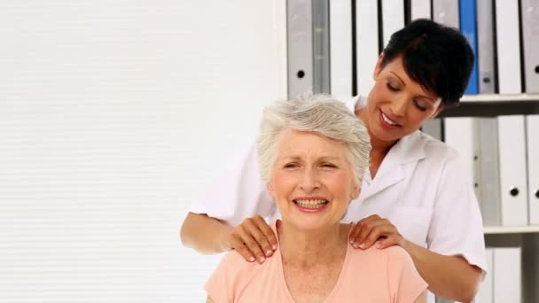 Nurse rubbing elderly patients shoulders — Stock Video