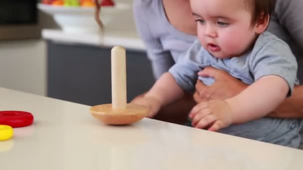 Mãe sentada com menino no colo brincando com brinquedo de madeira — Vídeo de Stock