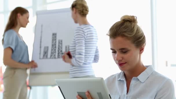 Businesswoman using tablet with colleagues behind her — Stock Video