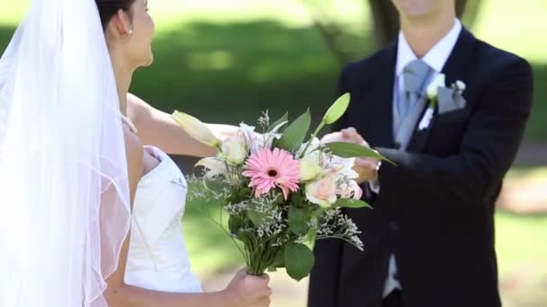 Felices recién casados de pie en el parque tomados de la mano — Vídeos de Stock