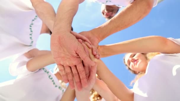 Gönüllüler birlikte ellerini koyarak — Stok video