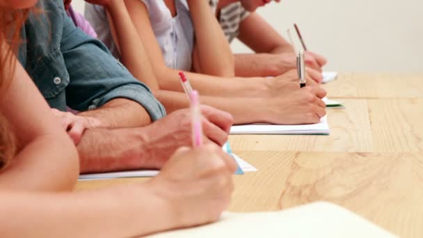 Estudiantes sentados en clase tomando notas — Vídeos de Stock