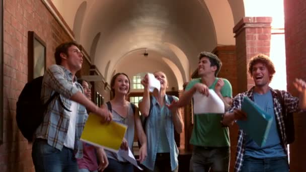 Gelukkig studenten springen in de lucht in een gang — Stockvideo