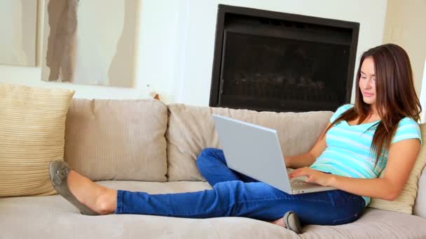 Brunette relaxing on the couch using laptop — Stock Video