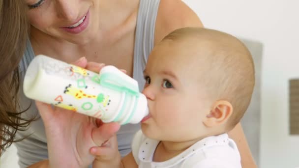 Madre alimentar a su bebé niña un biberón — Vídeo de stock