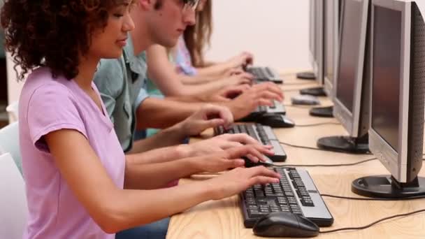 Estudiantes trabajando en sala de ordenadores — Vídeos de Stock