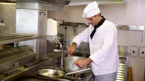 Красивый шеф-повар, помешивающий большой горшок — стоковое видео