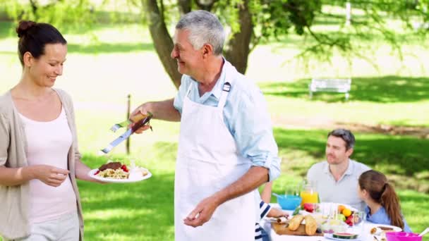 Abuelo sirviendo hamburguesas en la barbacoa familiar — Vídeo de stock