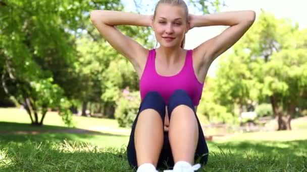 Přizpůsobit blondýnka dělá sit ups na trávě — Stock video