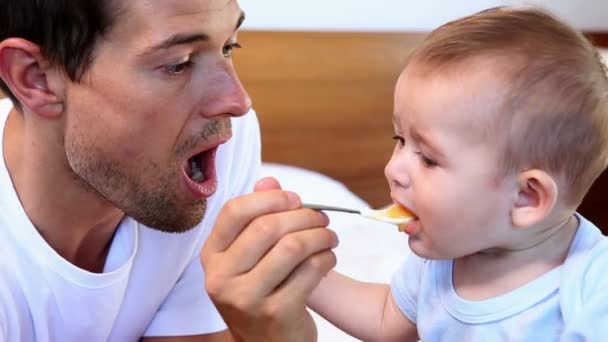 Glücklicher Vater füttert seinen kleinen Sohn — Stockvideo