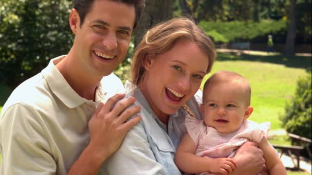 Parents holding their baby daughter in the park — Stock Video