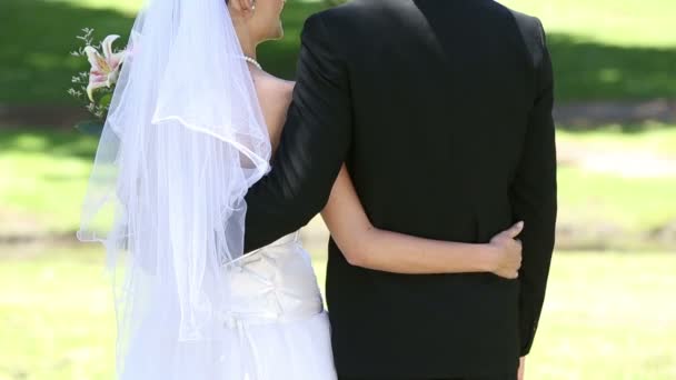 Heureux jeunes mariés debout dans le parc — Video
