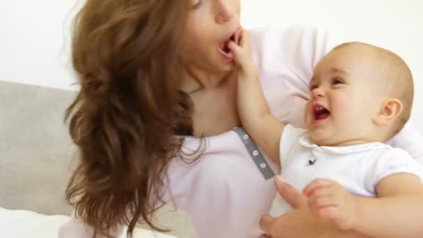 Madre jugando con la niña en la cama — Vídeos de Stock