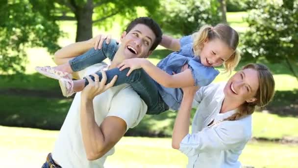 Happy parents with their little girl in the park — Stock Video