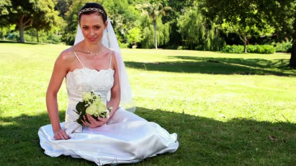 Contenu mariée assis sur l'herbe — Video