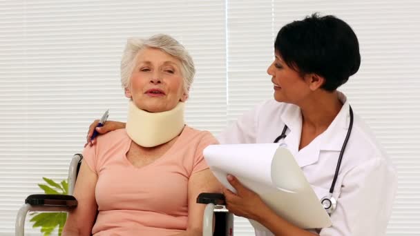 Enfermera hablando con paciente anciano en silla de ruedas — Vídeos de Stock