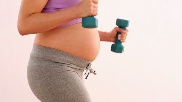 Pregnant woman lifting dumbbells — Stock Video