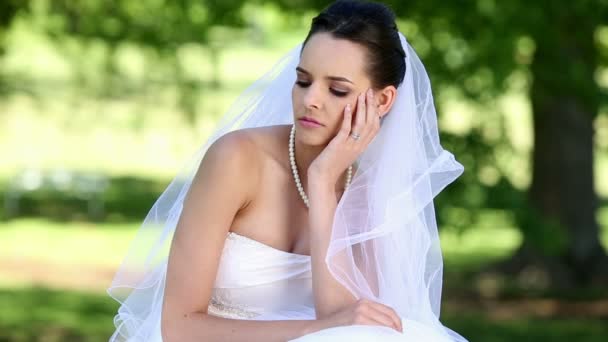 Upset bride sitting on the grass — Stock Video