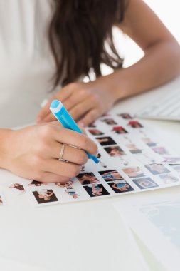 Editor working at desk marking a contact sheet clipart