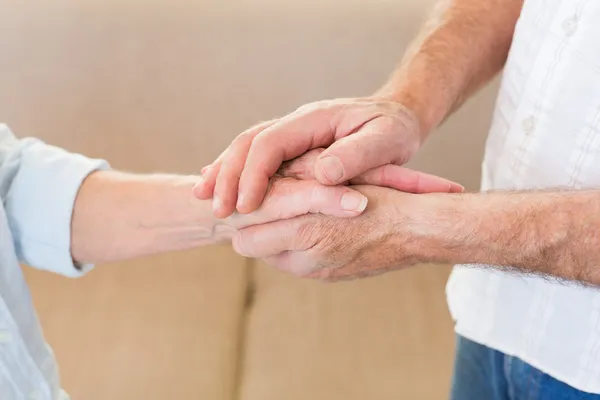 Retired couple touching hands — Stock Photo, Image