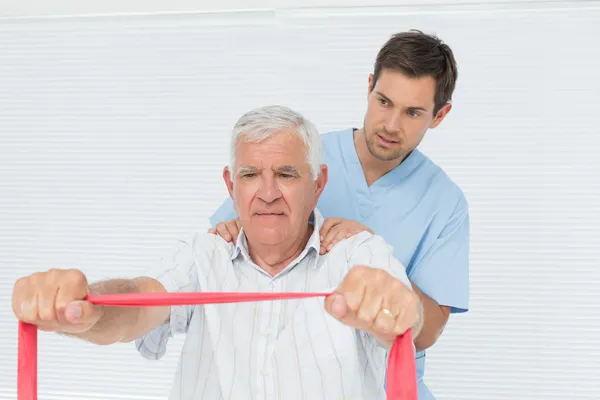 Fisioterapeuta masculino masajeando a hombres mayores espalda —  Fotos de Stock