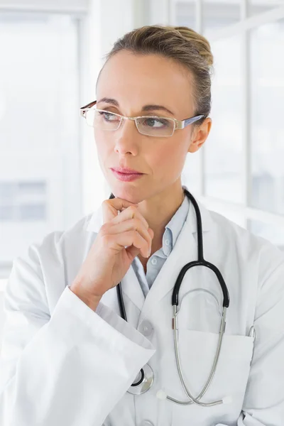 Contemplative beautiful female doctor in hospital — Stock Photo, Image