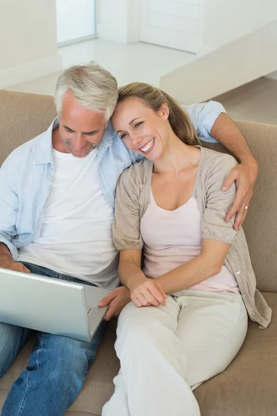 Ευτυχισμένο ζευγάρι χρησιμοποιώντας το laptop μαζί στον καναπέ — Φωτογραφία Αρχείου