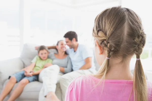 Klein meisje kijken naar haar familie op de Bank — Stockfoto