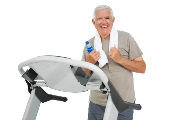 Feliz hombre mayor corriendo en una cinta de correr — Foto de Stock