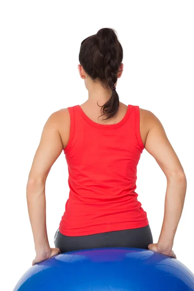 Rear view of a fit woman sitting on exercise ball — Stock Photo, Image