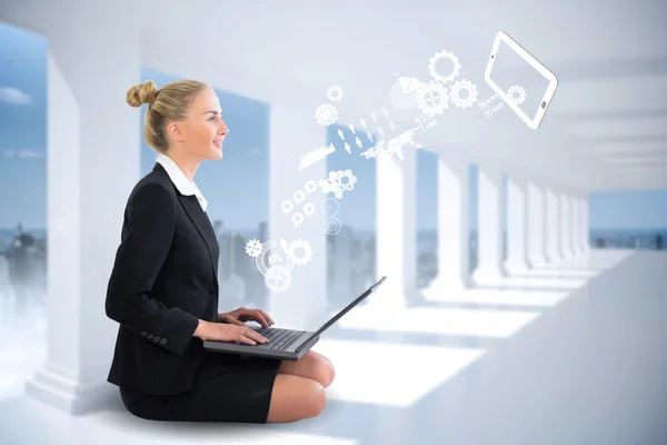 Businesswoman using laptop with cogs and wheels — Stock Photo, Image