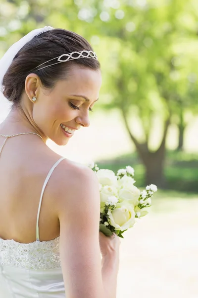 Schüchterne Braut mit Blumen im Garten — Stockfoto