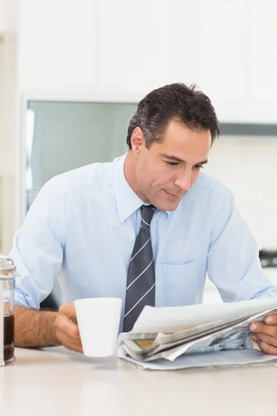 Man met koffiekopje krant lezen — Stockfoto