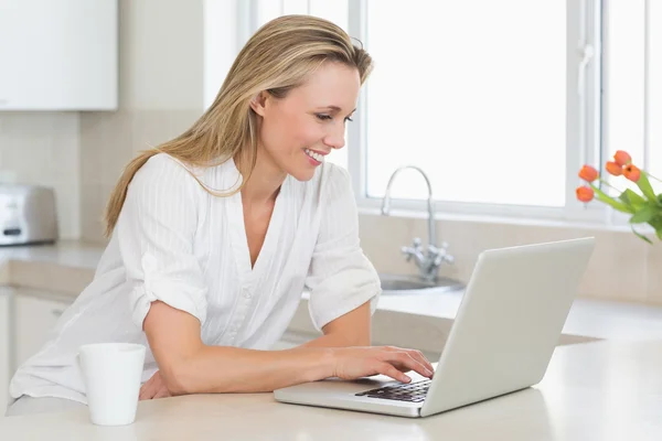 Glad kvinna med laptop på counter — Stockfoto