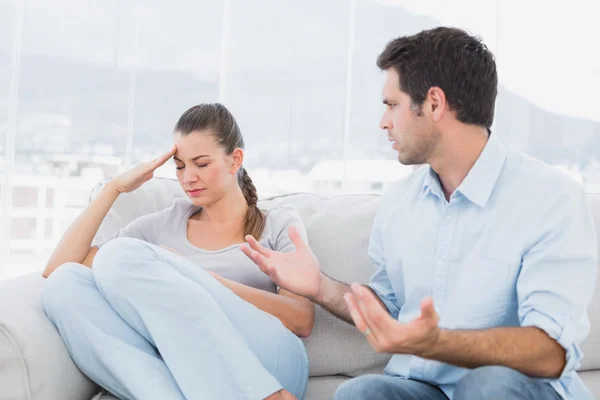 Man pleading with his upset partner on the couch — Stock Photo, Image