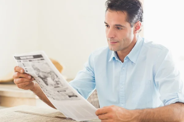 Hombre leyendo el periódico en la cocina — Foto de Stock