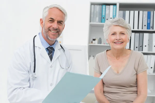 Retrato de un médico y paciente mayor con reportes —  Fotos de Stock