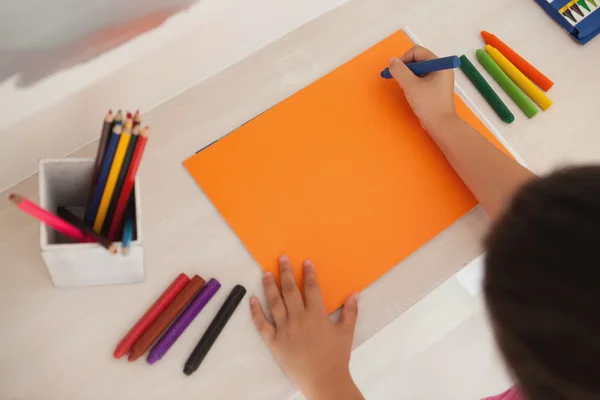 Mädchen zeichnet zu Hause auf orangefarbenem Papier — Stockfoto