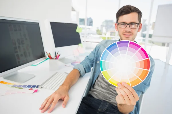 Artista masculino segurando roda de cores na mesa — Fotografia de Stock