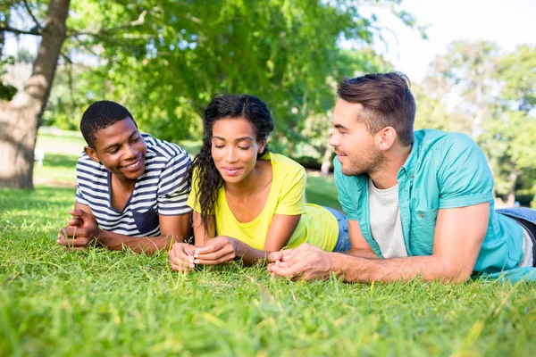 Vänner som ligger på gräset på campus — Stockfoto