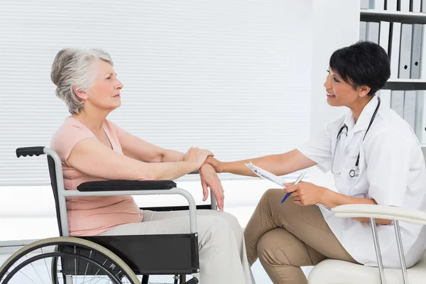 Médico falando com um paciente sênior em cadeira de rodas — Fotografia de Stock