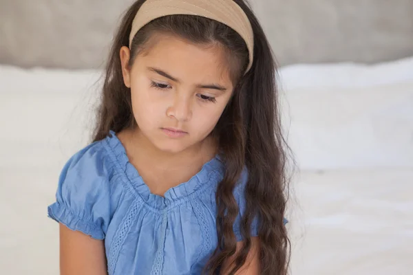 Sad girl sitting on bed — Stock Photo, Image