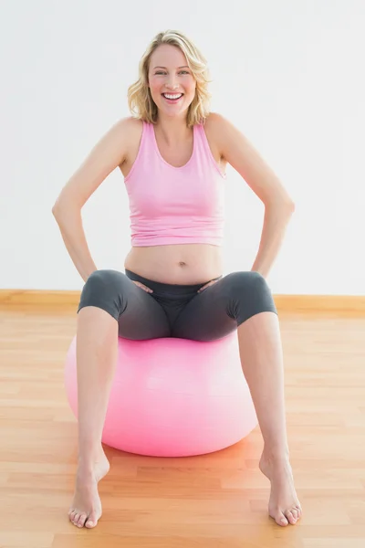 Mulher grávida loira alegre sentada na bola de exercício — Fotografia de Stock